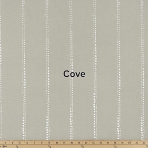 May include: A close-up of a light gray fabric with white dotted lines. The fabric has a subtle texture and the lines are evenly spaced. The word "Cove" is printed in black letters in the center of the image.