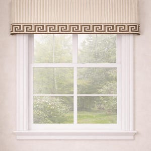 May include: A window with a cream-colored valance featuring vertical stripes and a brown Greek key design. The window frame is white, and the view outside shows green trees and foliage.