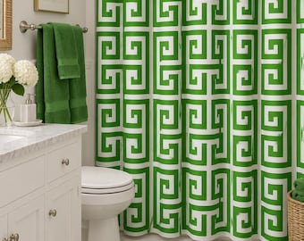 May include: A shower curtain featuring a repeating geometric Greek key pattern in vibrant green and white. The curtain hangs from a metal rod with rings, displaying a bold, symmetrical design that covers the entire length of the fabric panel.