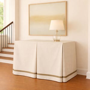 May include: A white ceramic mug with a black handle and the text "But First, Coffee" in a black, handwritten-style font. The mug is on a white surface.