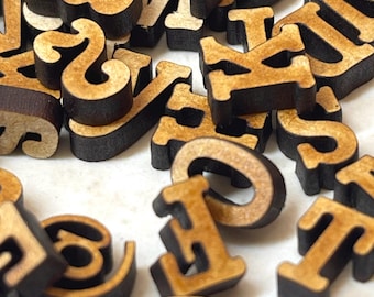 May include: A collection of wooden letters and numbers in various fonts. The letters and numbers are light brown with dark brown edges, scattered on a white surface. The image is a close-up shot, highlighting the details of the wooden pieces.