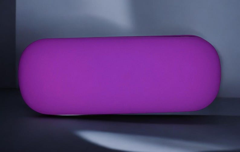 May include: A bright purple, oval-shaped, soft, plush cushion.
