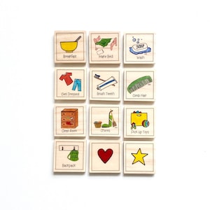 May include: A set of 12 wooden picture cards with colorful illustrations and text. The cards feature daily routines such as breakfast, make bed, wash, get dressed, brush teeth, comb hair, clean room, chores, pick up toys, backpack, a heart, and a star.