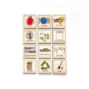 May include: A set of 12 wooden tiles with illustrations and text depicting various kitchen chores. The tiles feature images of a chef, setting the table, clearing the table, clearing dishes, washing dishes, loading the dishwasher, unloading the dishwasher, putting food away, wiping the table, taking out the garbage, recycling, and sweeping.