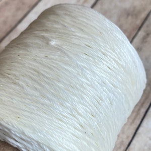 May include: A spool of white waxed cord, perfect for crafting and jewelry making.