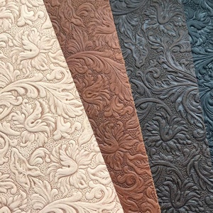 May include: Four samples of embossed leather fabric in different colors: off-white, brown, dark brown, and black. The fabric has a floral pattern.