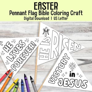 Puede incluir: Banderines triangulares blancos con texto negro, parte de una manualidad de colorear la Biblia con temática de Pascua. Las banderas dicen "HE LIVES FOREVER!", "HE IS RISEN" y "VICTORY in JESUS". También se ven crayones y tijeras.