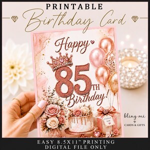 Könnte beinhalten: Eine druckbare Geburtstagskarte mit dem Text Happy 85th Birthday in roségoldenem Glitzer. Das Design zeigt eine roségoldene Krone, Luftballons, ein Blumenarrangement und ein Geschenk. Format für den Druck auf 8,5x11 Zoll Papier.