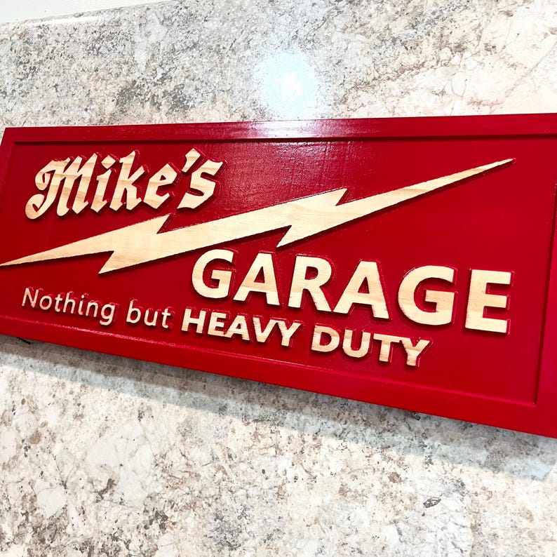 May include: Red wooden sign with a lightning bolt and the text "Mike's Garage Nothing but HEAVY DUTY".