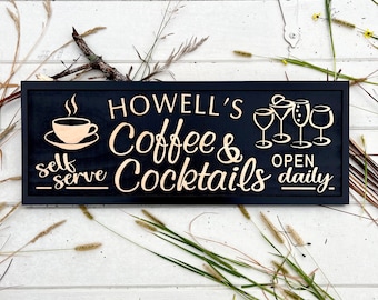 May include: Black wooden sign with gold lettering that reads "Howell's Coffee & Cocktails - self serve - Open daily". The sign features a coffee cup and saucer and four cocktail glasses.