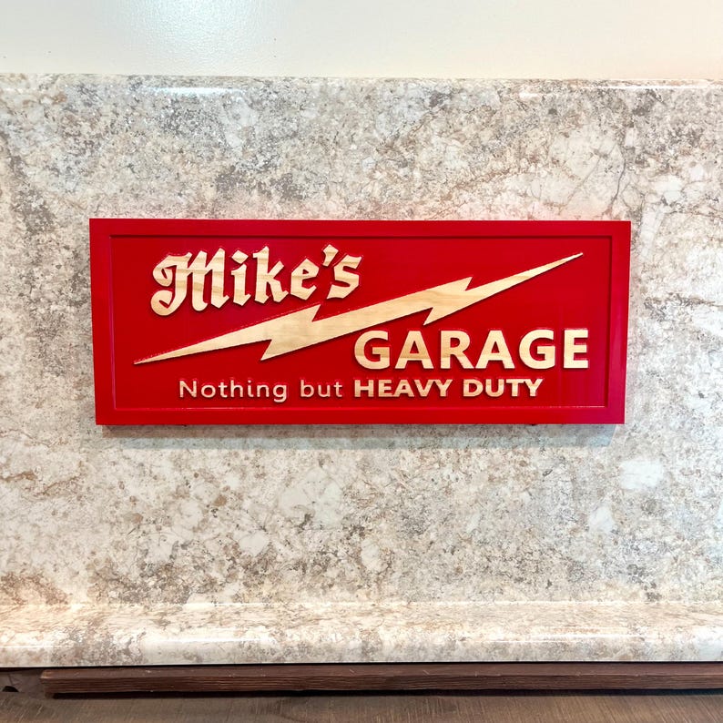 May include: Red wooden sign with a lightning bolt and the text "Mike's Garage Nothing but HEAVY DUTY".