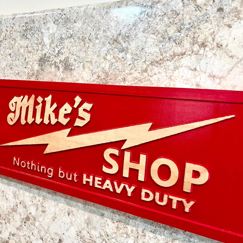 May include: Red wooden sign with a lightning bolt and the text "Mike's Shop Nothing but Heavy Duty".