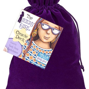 May include: A purple velvet bag with a drawstring closure. The bag contains a deck of oracle cards with the title "The Geeky Girl Oracle Deck" and an illustration of a girl with glasses and a name tag that reads "Hello, my name is Geeky Girl".