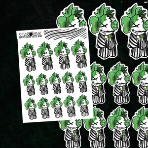 May include: A sheet of stickers featuring a cartoon character with green hair, a stitched-up face, and a black and white striped outfit. The character is repeated multiple times on the sheet. The text "SEASINK VDBB BEETLE JUICE MINI" is at the top of the sheet.