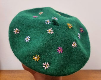 Dark green beret hat with hand stitched daisy flowers in blush pink fuchsia lilac and mustard yellow