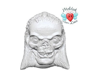 May include: A white 3D printed model of a creature with a skull-like face and long hair.
