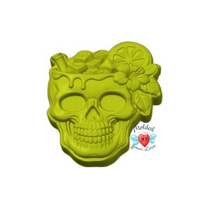May include: A lime green silicone mold shaped like a human skull with a tropical drink theme. The top of the skull features ice cubes, a lime slice, and a hibiscus flower. The text Molded from Love with a small heart icon is visible.