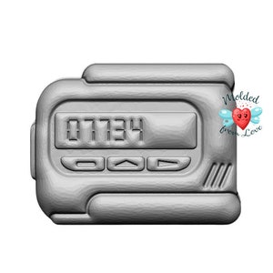 May include: A silver-colored pager with a digital display showing the number 07734. The pager has three buttons: a circle, an arrow pointing up, and an arrow pointing to the right.