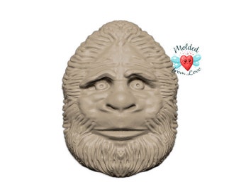 Könnte beinhalten: Ein detailliertes, modelliertes Gesicht eines Bigfoots mit einem buschigen Bart und einem ernsten Ausdruck. Die Skulptur ist aus hellem braunen Material gefertigt und eine realistische Darstellung der mythischen Kreatur.