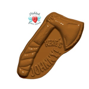May include: Brown plastic mould of an axe with a wooden handle. The mould has the text "Here's Johnny!" on it.