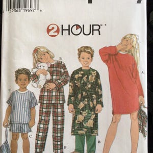 May include: Simplicity sewing pattern 7407 for children's sleepwear. The pattern features illustrations of children in pajamas, a nightgown, and a robe. The pattern includes sizes 3, 4, 5, and 6. The text "2 HOUR" is visible.