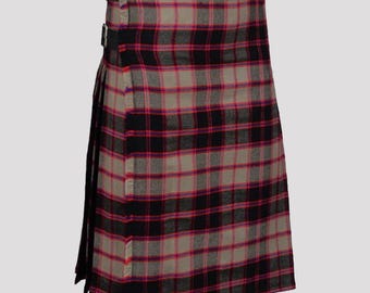 Puede incluir: Un kilt tradicional con un patrón de cuadros negro, rosa y gris. El kilt tiene una correa de cuero con hebillas.