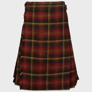 Op de afbeelding: Een rode, zwarte en gouden tartan kilt met een gefranst uiteinde.