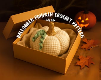 May include: A cream-colored crocheted pumpkin with a gold-colored stem and a green vine, presented inside an open orange box. The text HALLOWEEN PUMPKIN CROCHET PATTERN Pdf File is displayed in white letters across the top of the image.