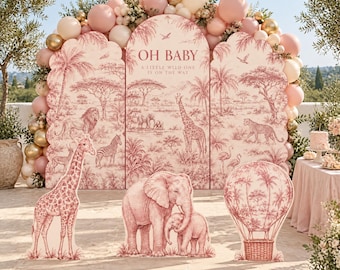 May include: A three-panel arched backdrop featuring a pink and white toile safari print with the text OH BABY A LITTLE WILD ONE IS ON THE WAY. Includes freestanding cutouts of a giraffe, an elephant with a calf, and a hot air balloon.