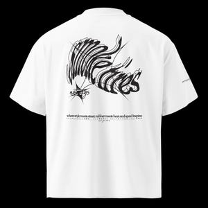 May include: White t-shirt with a black abstract design on the back. The design includes the text "not rags" and the phrase "where style meets street, rubber meets heat and speed inspires".