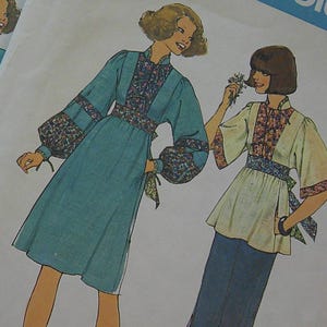 May include: Two vintage Simplicity sewing pattern envelopes. The envelopes feature illustrations of women's clothing designs, including dresses and tops. The patterns are labeled "7517" and include size information. The background is a white fabric with brown polka dots.