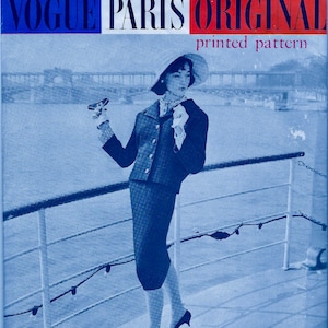 May include: A black and white photograph of a woman wearing a blue suit and a hat, standing on a boat deck. The text "Vogue Paris Original printed pattern designed by Jacques Heim" is visible in the image.