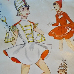 May include: Vintage sewing pattern featuring illustrations of majorette costumes. The main image shows a white and gold uniform with a matching hat and boots. Other designs include an orange dress with a hood and a green and yellow outfit.