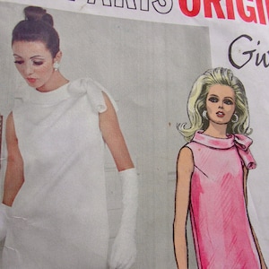 May include: Two fashion illustrations of women wearing sleeveless dresses with a bow detail at the neck. The dress on the left is white and the dress on the right is pink. The illustration includes the text "Givenchy 192"