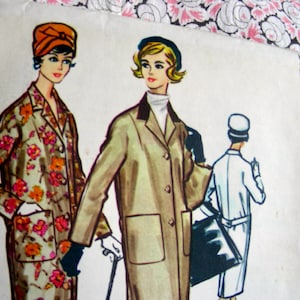 May include: A vintage McCall's printed pattern for a coat and dress. The pattern features three women wearing different styles of clothing. The woman on the left is wearing a floral print dress with a red headband. The woman in the center is wearing a brown coat with a white collar. The woman on the right is wearing a white dress with a white hat.