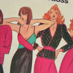 May include: Four women are wearing different styles of clothing. The woman on the left is wearing a pink jacket with a diamond pattern. The woman in the centre is wearing a black and teal dress with a pink sash. The woman on the right is wearing a black and pink dress with a black sash. The woman at the back is wearing a black and green dress with a pink sash.