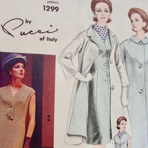 May include: A vintage sewing pattern by Pucci of Italy, featuring a light blue coat with a white collar and a matching dress. The pattern number is 1299.