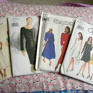 May include: Four different sewing patterns for clothing. The patterns are Vogue, Simplicity, and McCall's. The patterns are for dresses, skirts, and tops.