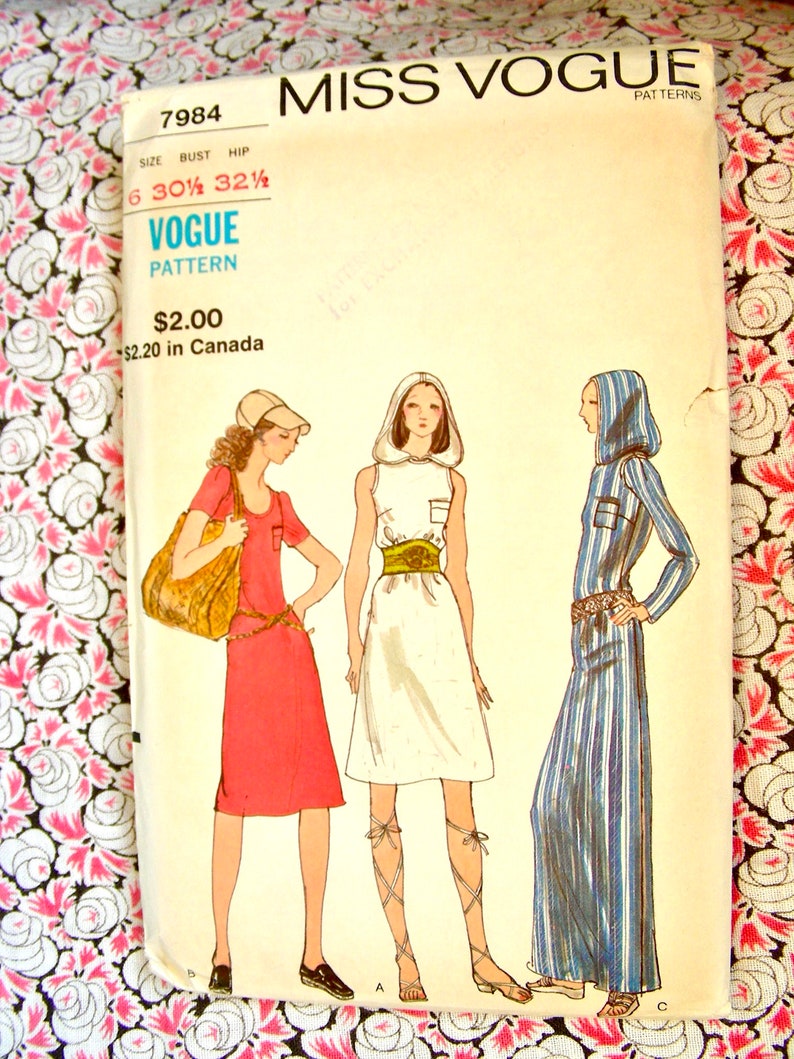 Op de afbeelding: Vintage naaipatroon voor een jurk met een wit, blauw en rood gestreept patroon. Het patroon is van Miss Vogue Patterns en heeft nummer 7984. Het patroon is voor maten 6, 30 1/2 borstomvang en 32 1/2 heupomvang.
