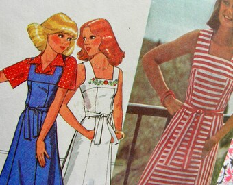 May include: Three women's dresses in different styles. The first dress is blue with white polka dots and a white collar. The second dress is white with a floral pattern and a white sash. The third dress is red and white striped with a white sash.