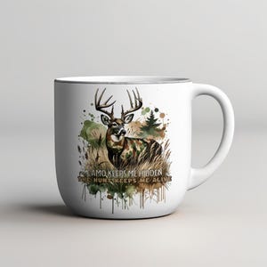 May include: White ceramic mug featuring a watercolour design of a deer in camouflage with the text "Camo keeps me hidden, the hunt keeps me alive".