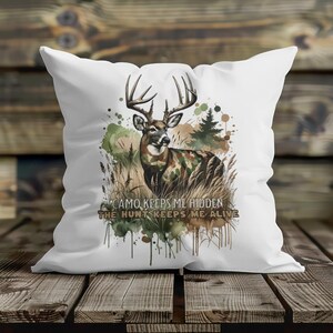 May include: White throw pillow with a watercolour design of a deer in camouflage with the text "Camo keeps me hidden, the hunt keeps me alive".