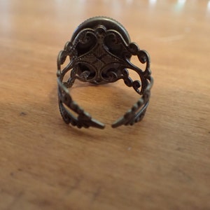 K&ouml;nnte beinhalten: Ein silberner Ring mit einem verzierten Design. Der Ring ist hinten offen und hat ein filigranes Design.