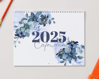 May include: A white calendar with a blue floral design and the year 2025 printed in dark blue. The text "Calendar" is written in cursive below the year.
