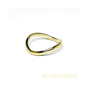 wavy gold ring against a white background