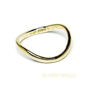 wavy gold ring against a white background showing hallmarked stamped on the inside band of the ring