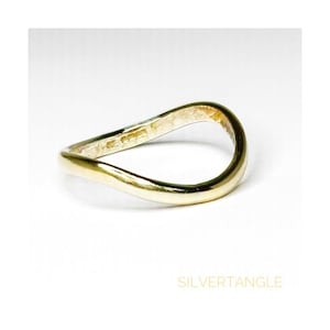 wavy gold ring against a white background showing hallmarked stamped on the inside band of the ring