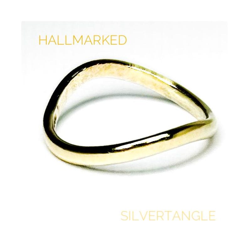 wavy gold ring against a white background