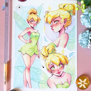 Può includere: Una stampa artistica rettangolare con tre illustrazioni di una fata con capelli biondi raccolti in uno chignon, ali verdi e un vestito verde. Il personaggio è raffigurato in una posa a figura intera e in due ritratti con tenui accenti rosa e blu.