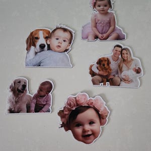 May include: Five different photo cards featuring children and dogs. The cards are printed on white cardstock and have a white border. The first card shows a baby boy and a beagle dog. The second card shows a young girl wearing a pink dress and a flower in her hair. The third card shows a baby girl wearing a pink flower crown. The fourth card shows a baby girl and a golden retriever dog. The fifth card shows a family of three with a golden retriever dog.